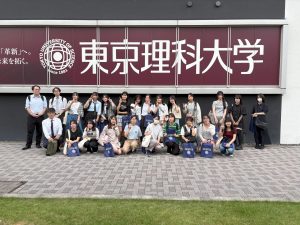 東京理科大学の看板の前で